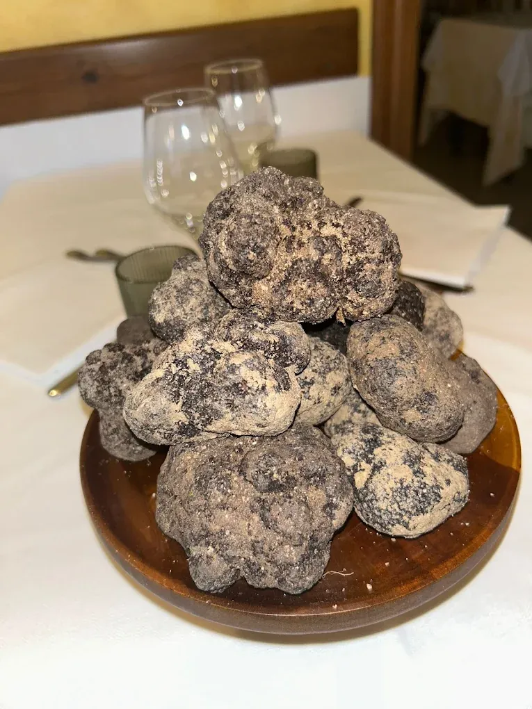 Tartufi neri interi su un piatto di legno